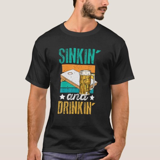 「シンおもしろいキン」と「飲み物」のコーンホールビール飲用 Tシャツ (正面)
