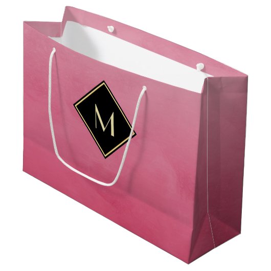 シンプルな金ゴールドのモノグラムとのエレガントなブラシをかけられたピンク ラージペーパーバッグ (正面アングル)