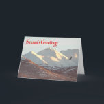 シーズンの挨拶 – Winter Eagle シーズンカード<br><div class="desc">ハゲのワシが、アンカレッジ近郊の雪に覆われたChugach Rangeの近くを飛ぶ。文字読の「シーズングリーティング」は赤で表示される。</div>