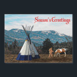 シーズンズグリーティング – Winter Camp<br><div class="desc">太平洋北西部のティピの近くに先住民のアメリカ人とその馬のイメージ。背景の山々の高斜面に雪が定着している。文字読の「Season's Greetings」が赤で表示される。</div>