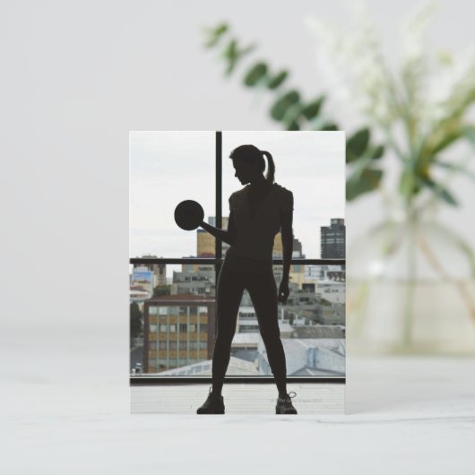 ジムで重りを持ち上げる女性のシルエット ポストカード (スタンド正面)