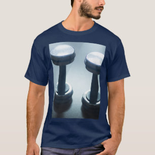 ジムのヘルスクラブでダンベルジムの金属の重り Tシャツ