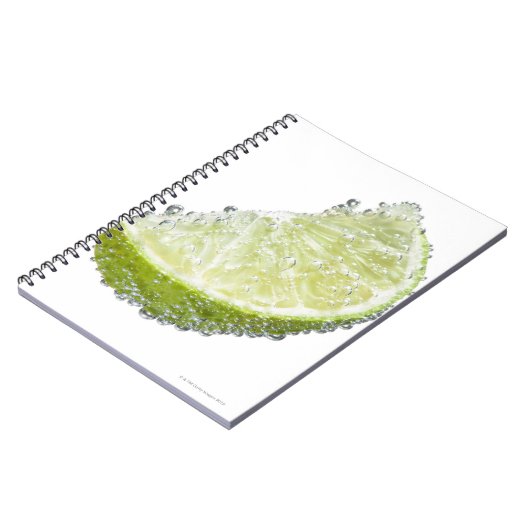 ジューシーな熟したオーガニックライムのくさび果実が水没した ノートブック (左側)