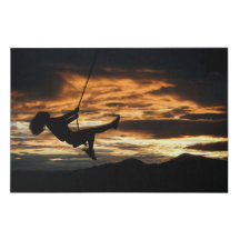 スウィングの女の子のサンセットシルエット