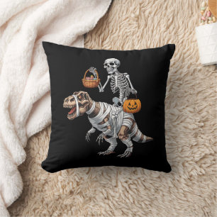 スケルトンがミイラに乗ってハロウィンを楽しむティラノサウルス クッション