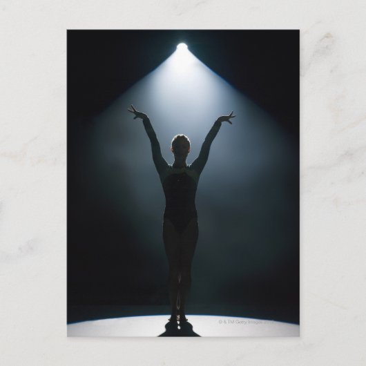 スタジオのスポットライトを浴びて演技する女性体操選手 ポストカード (正面)