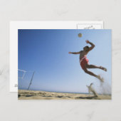 スパイクまで跳んでいるオスのビーチバレープレーヤー ポストカード (正面/裏面)