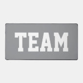スポーティーでビッグでボールドな「TEAM」白文字 on 薄灰色 デスクマット (正面)