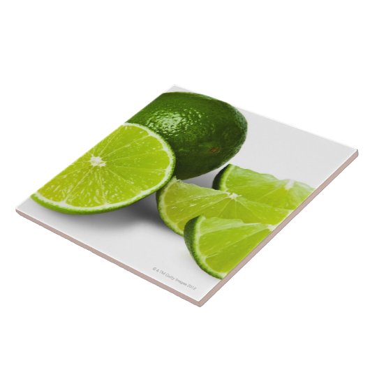 スライスされたライムのくさびは、白い背景で、切り取りました タイル (側面)