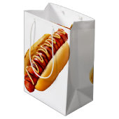スリップリージョーのホットドッグ、柔らかなパンに収まり、鮮やかな黄色のマスタードソースがスパイラルに ミディアムペーパーバッグ (裏面アングル)