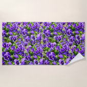 セレニティの海:美しい紫のパンジー畑 ビーチタオル (正面)