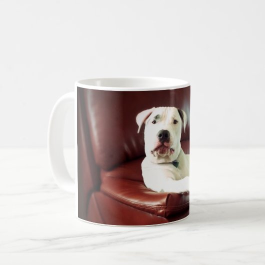 ソファおもしろいに座っている白いピットブルドッグ コーヒーマグカップ (正面左)