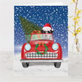 ダルメシアンの犬が雪の中で赤い車を運転するクリスマス カード (黄色い花)