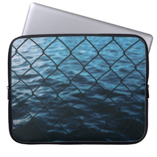 チェーンリンクフェンス前方の水体 ラップトップスリーブ