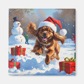 チベットのスパニエル犬走のクリスマス帽子と雪の中 マグネット (正面)