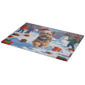 チベットテリア走ーのクリスマス帽子と雪の カッティングボード (角)