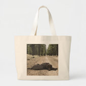 チョコレートラブラドールの子犬が森林道に横たわる ラージトートバッグ (正面)