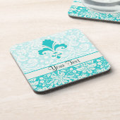 ティール(緑がかった色)の(紋章の)フラ・ダ・リ コースター (左側)