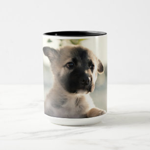 ドイツの羊飼いの子犬がレッジの上に マグカップ