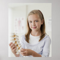 ドクターオフィスで背骨のモデルを保持する少女