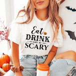 ドリンクと怖い食べタイポグラフィモダンハロウィン トライブレンドＴシャツ<br><div class="desc">オレンジ色のジャックオランタンカボチャのアクセントと文字が付いた黒いタイポグラフィデザインに食べ「ドリンクと怖がる」というフレーズを付け加え、お名前や家族の名前で表現できる恐ろしいかわいい女性のグラフィックTシャツでパーソナライズされたす。</div>