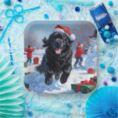 ニューファンドランド走のクリスマス帽子と雪の中にある ペーパープレート (パーティー)