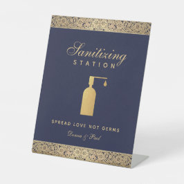 ネイビーブルーの背景にゴールドのバラの花飾りが施された、エレガントなウェディング用のサニタイズステー 台座サイン