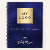 ネイビーブルーの背景に金色のロゴマークと社名、そして設立年 ノートブック (正面)