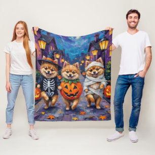 ハロウィンのかぼちゃの衣装を着たポメラニアンの犬たちと一緒に、ドアを叩いてお菓子をもらう フリースブランケット