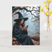 ハロウィンの箒に乗る携帯いじりの魔女 カード (黄色い花)