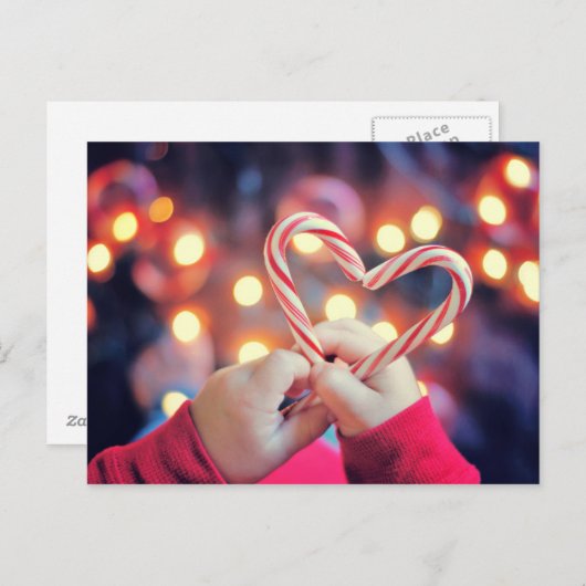 ハートの形のクリスマスキャンデーを握っている子供 シーズンポストカード (正面/裏面)