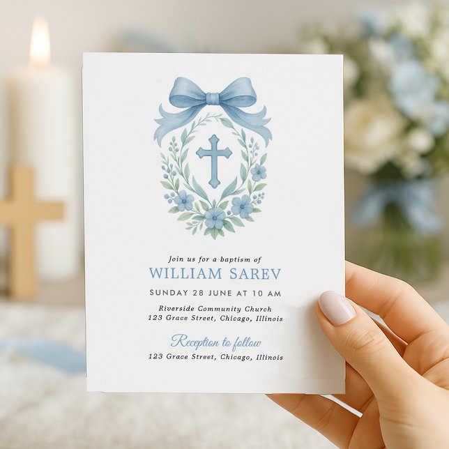 バジェットシンプルブルーボーイバプテスマ招待状ウィズボウ (Elegant boy baptism invite with blue bow and floral cross – held in hand near candlelight)