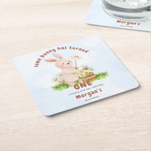 バニーが1つの可愛いベビーうさぎ1歳の誕生日を回している スクエアペーパーコースター (アングル)