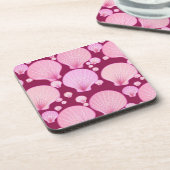 バーガン色の背景コースターにピンク色の貝殻 コースター (左側)