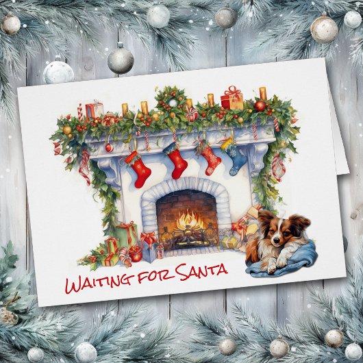 パピヨン犬がサンタクリスマス暖炉を待つ