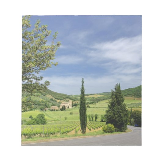 ヒノキの木々の間を曲がる田舎道 ノートパッド (正面)