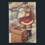 ビクトリア時代のクリスマス ヴィンテージサンタクロースが煙突を降りる キッチンタオル<br><div class="desc">ビクトリア時代のイラスト ヴィンテージ メリークリスマスの休日イメージ。白ひげと帽子をかぶった陽気な老サンタクロース、セントニコラスが、クリスマスイブに、たくさんの玩具を入れた袋を背負って、家の煙突を降りる様子を描いたもの。ハッピーホリデー＆シーズンギーティング！</div>
