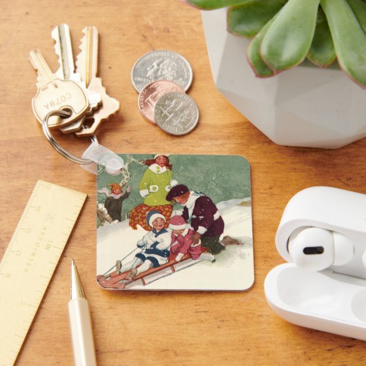 ビンテージクリスマス、雪の中で子供たちがスレッドに乗って遊ぶ キーホルダー (デスク)