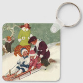 ビンテージクリスマス、雪の中で子供たちがスレッドに乗って遊ぶ キーホルダー (裏面)