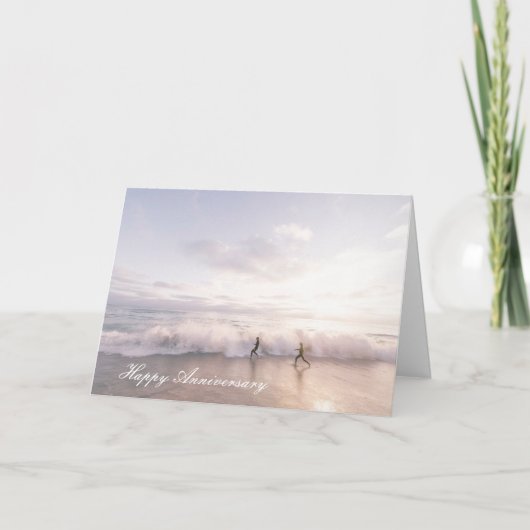 ビーチを駆けるカップルの記念日カード カード (正面)