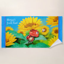 ビーチタオルの眠いてんとう虫のヒマワリ。 青い端