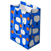 ピクルボールパドル、オレンジ色のピックルボールボール、ブルー ミディアムペーパーバッグ (正面アングル)