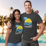 ピックボールトロピカルパームツリーサンユーカスタム文字 Tシャツ<br><div class="desc">熱帯性のヤシの木と青い海波で囲まれたピックボール「太陽」を特徴とするおもしろいピックボールTシャツ。クラブカスタム名、ピックボール週末の日付/場所、トーナメント名、プレイヤー名など、以下の文字を追加。ピックボール選手に最適な贈り物を作る – トーナメントに適したTシャツとしての衣服遊、クラブチームに最適（単にあなたのクラブ/チーム名を追加）、レクリエーション選手、フロリダ遊、カリフォルニア、アリゾナなどのスノーバード選手。Tシャツの色やスタイルを簡単に変更。</div>