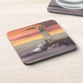 ピンクとオレンジ色の空を持つ海岸灯台 コースター (左側)