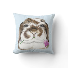 ピンクのチューリップを持つ愛らしいアメリカのファジーロップウサギ