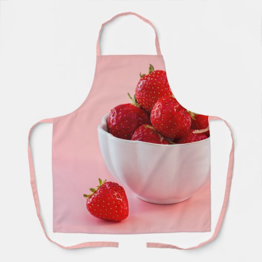 ピンクの写真に乗ったボウルに入った赤いイチゴ エプロン (正面)