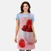 ピンクの写真に乗ったボウルに入った赤いイチゴ エプロン (着用した状態)