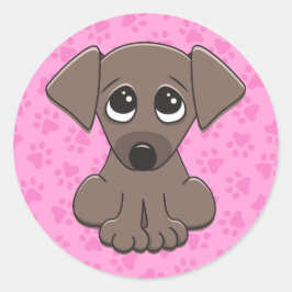 ピンクの前足のプリントの背景にかわいい茶色の子犬 ラウンドシール
