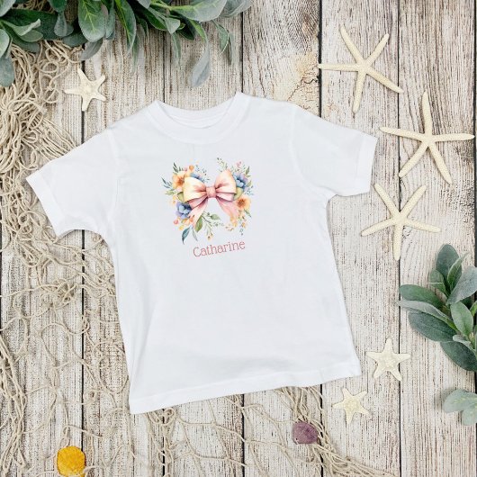 ピンクの弓モノグラムコケット水の色の花 ベビーTシャツ