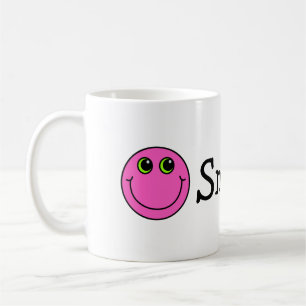 ピンクの微笑のEmojiは直面します コーヒーマグカップ